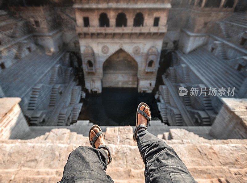 印度拉贾斯坦邦焦特布尔，一名游客在Toorji Ka Jhalra Bavdi世界著名的台阶上拍照。梯级井，通过一组梯级下降到水平面到达水的井